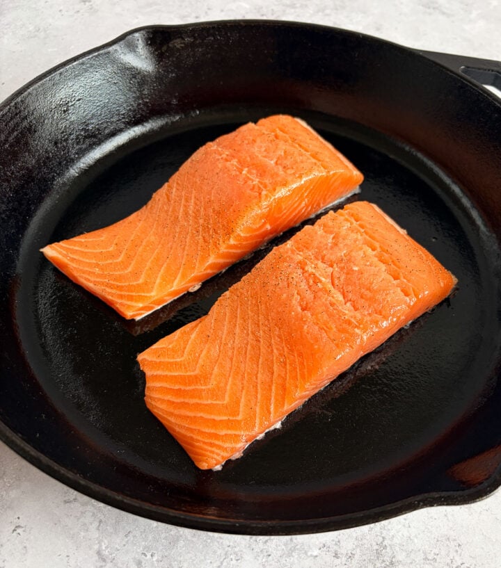 salmon brushed with olive oil, salt and pepper in a cast iron pan
