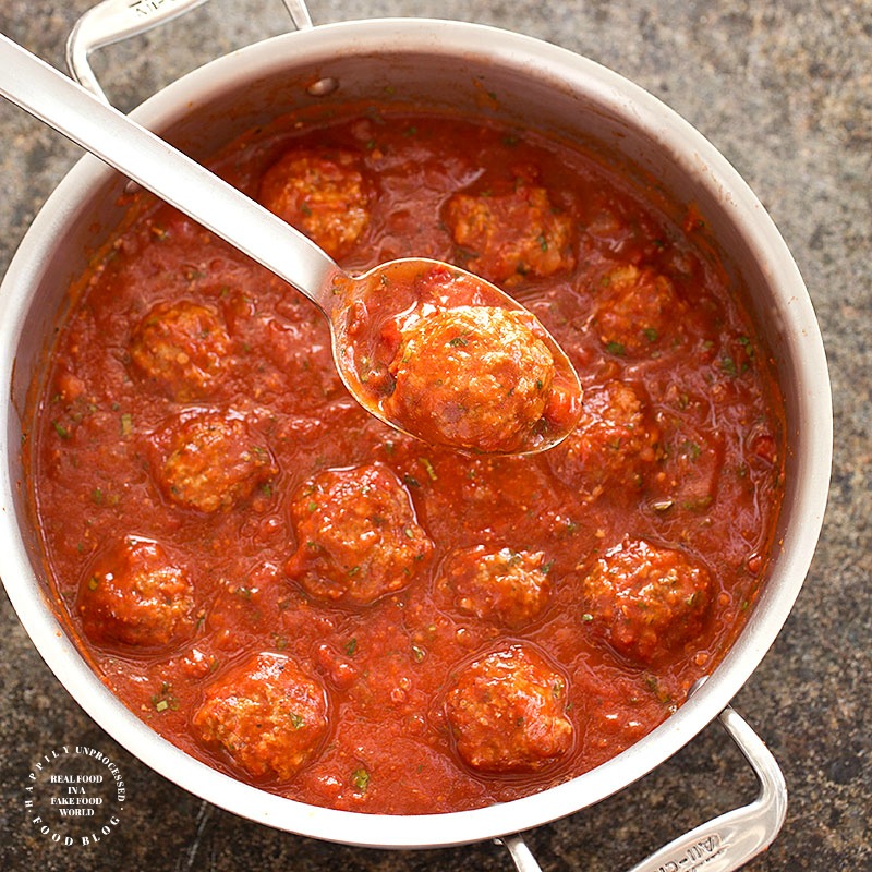 BAKED MEATBALLS simmering in a pot of homemade sauce on the stove - #spaghetti #meatballs #italian #dinner #happilyunprocessed
