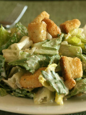 caesar salad with croutons on white plate