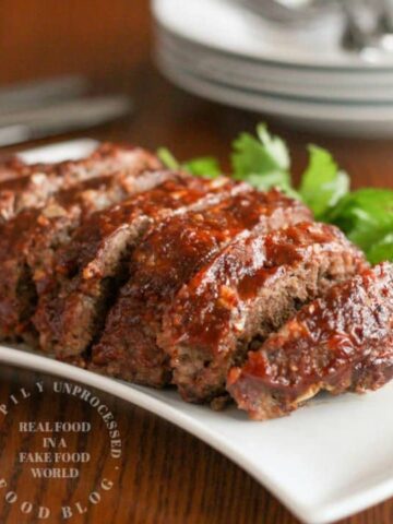 sliced meatloaf with honey whiskey bbq glaze on white plate