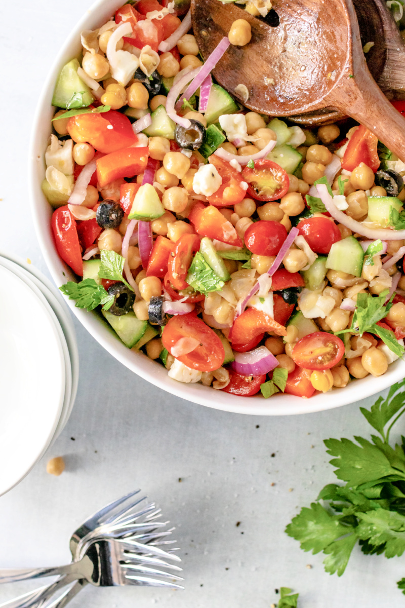 Mediterranean Chickpea and Feta Salad combined with a vinaigrette dressing in a bowl #chickpeasalad #summersalad #happilyunprocessed