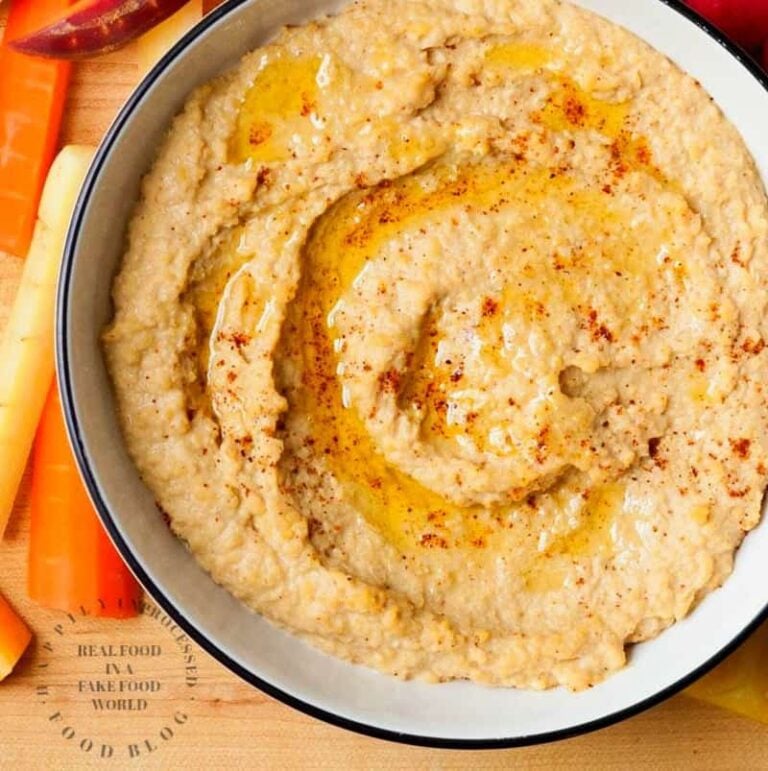 roasted red pepper hummus in bowl with extra olive oil with carrots