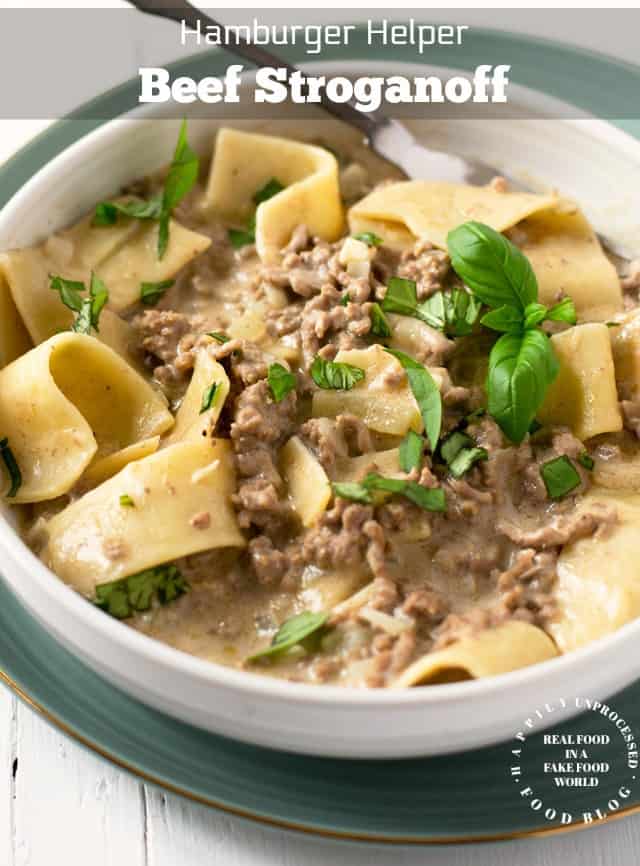 Hamburger Helper Beef Stroganoff in a white bowl with large egg noodles and garnished with parsley