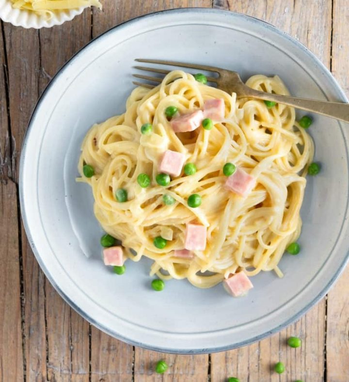 cheese spaghetti in a bowl with diced ham and peas #ham #tetrazzini #weeknightdinner #happilyunprocessed