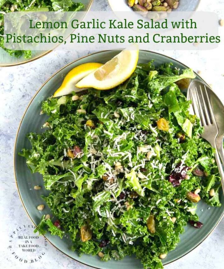 An easy lemony garlic kale salad with pistachios, pine nuts, dried cranberries topped with shaved parmesan cheese #newyearsresolution #kale #salad #healthy #happilyunprocessed