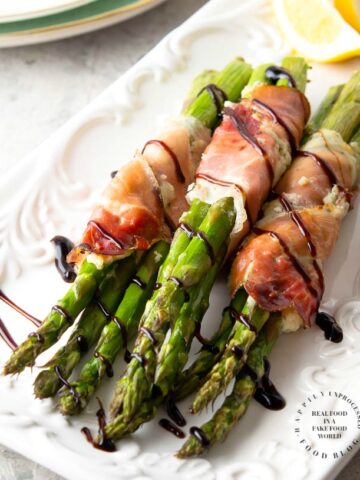 PROSCIUTTO WRAPPED ASPARAGUS - Garlic and Herb cheese is spread over prosciutto and then wrapped around fresh asparagus and baked until tender #asparagus #prosciutto #appetizer #happilyunprocessed