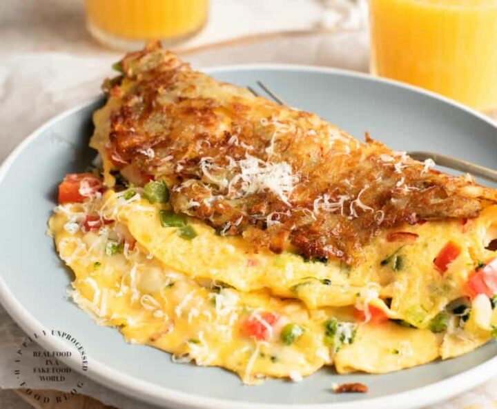 Hash Brown Wrapped Vegetarian Omelet - crispy golden hash browns form a perfect shell to wrap an omelet on the inside #breakfastfood #eggs #potatoes #hashbrowns #happilyunprocessed.com
