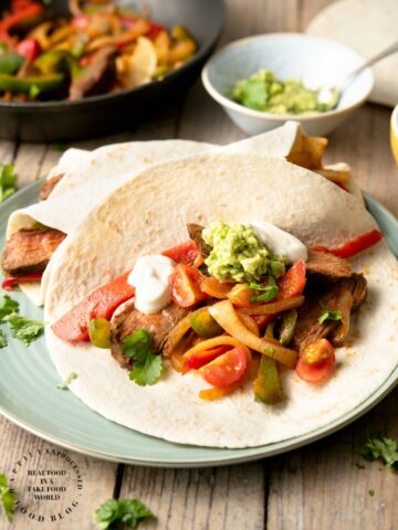 FLANK STEAK FAJITAS - perfectly grilled strips of flank steak with onions and peppers served with fresh tortillas, sour cream, guacamole and salsa #fajitas #happilyunprocessed