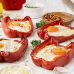 Egg stuffed red bell peppers with sunny side up eggs and cheese is a healthy breakfast