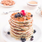 Homemade Blueberry Buttermilk Pancakes in a stack on a plate with fresh fruit