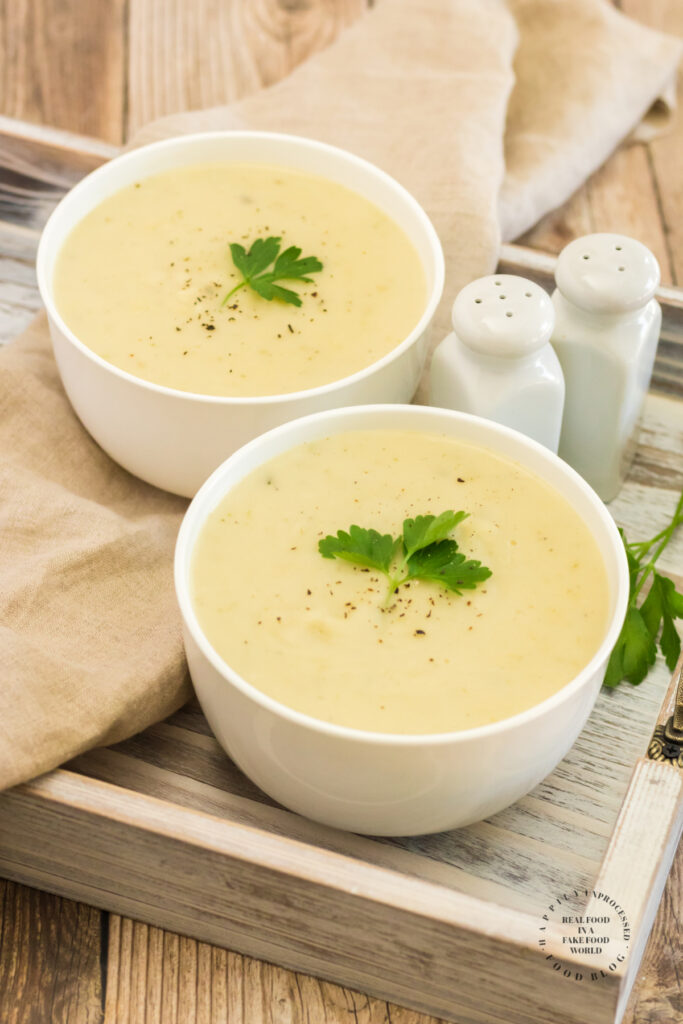 Healthy Potato Leek Soup in a white bowl with fresh parsley