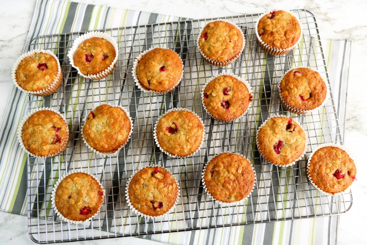 A dozen freshly baked cranberry banana muffins on a cooling rack
