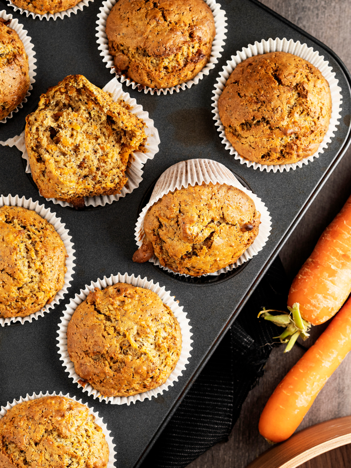a muffin tin with freshly baked carrot cake muffins
