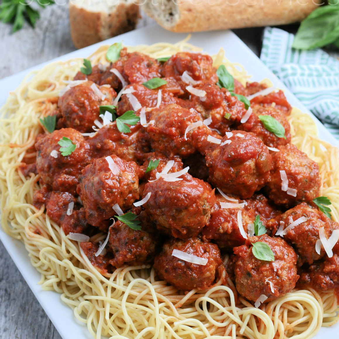 A big plate of spaghetti and baked meatballs with sauce