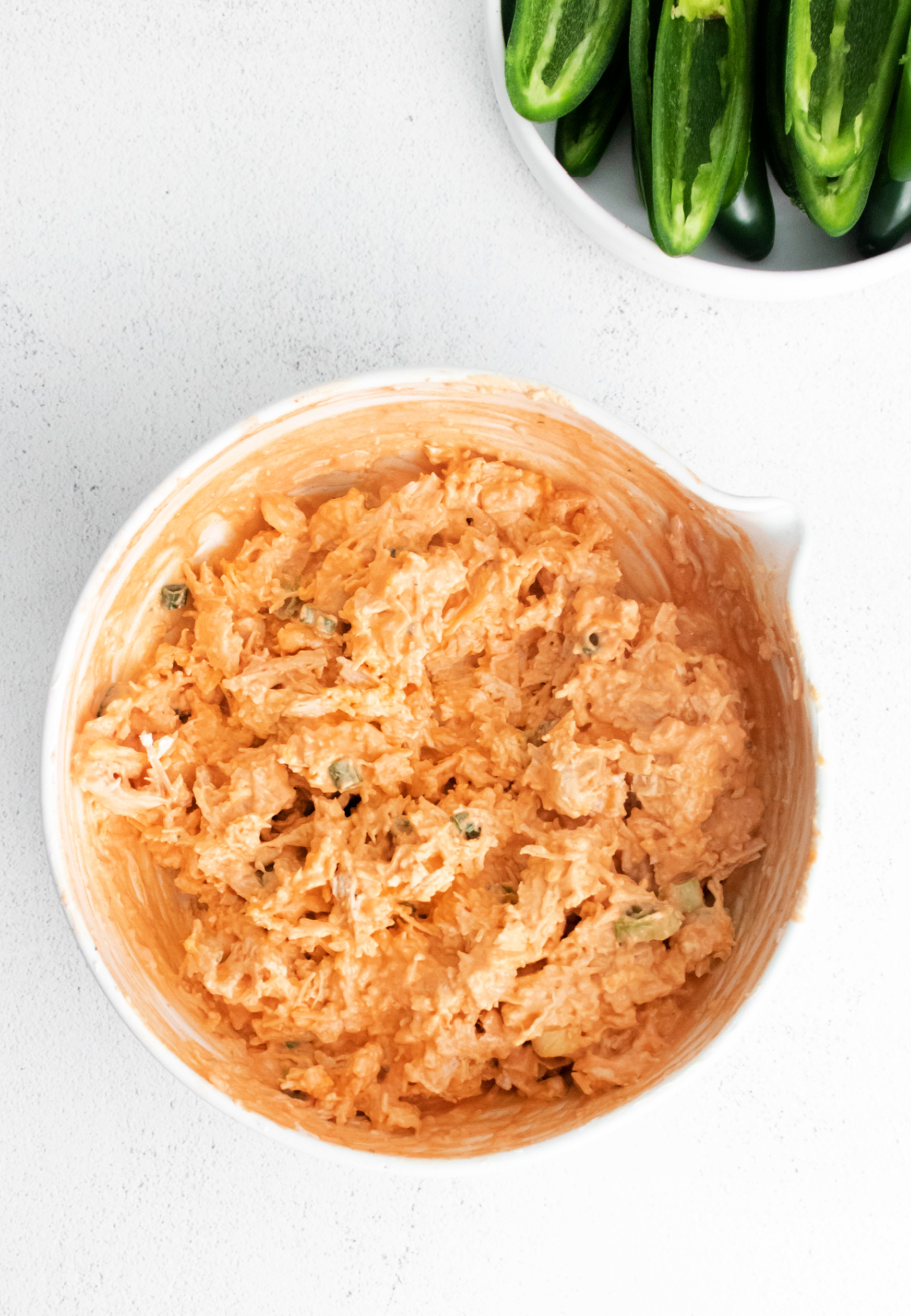 A big bowl of buffalo chicken ready to be stuffed into jalapeno peppers