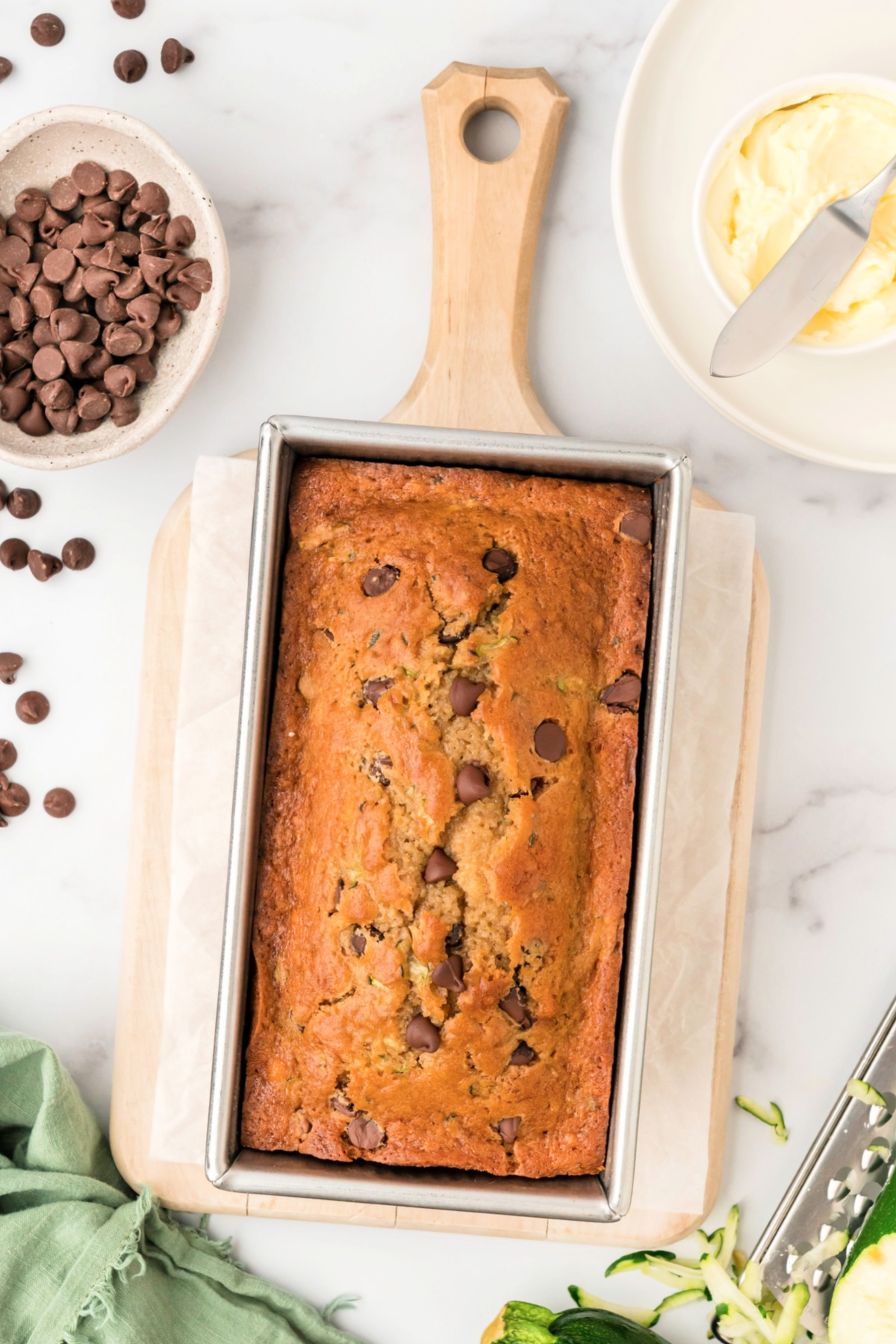 a loaf of freshly baked chocolate chip zucchini bread in a loaf pan