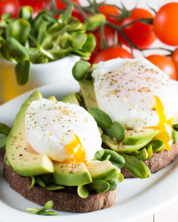 a perfectly poached egg with fresh avocado on toast