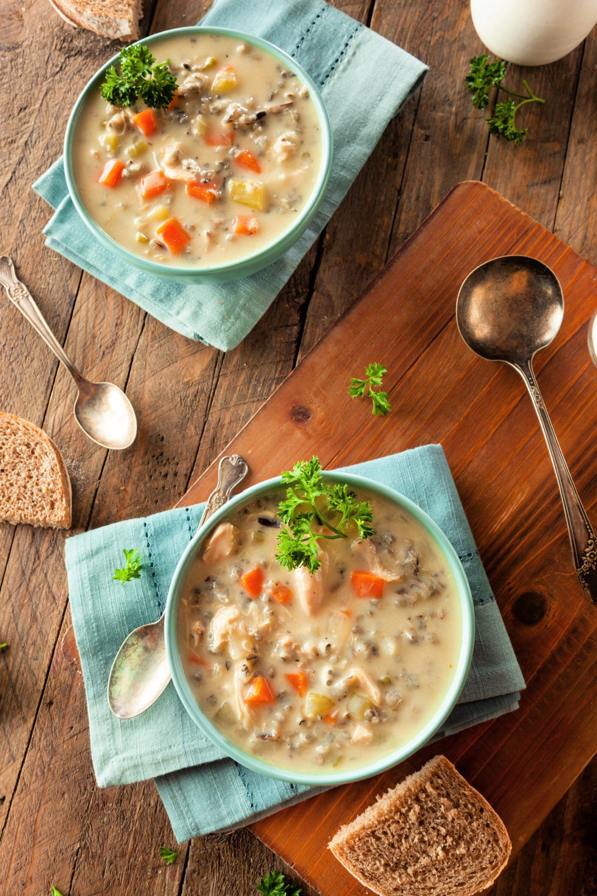 A bowl of creamy chicken and wild rice soup with bread