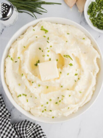 Garlic mashed potatoes with chives and butter in a bowl.