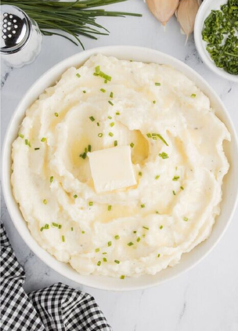 Garlic mashed potatoes with chives and butter in a bowl.