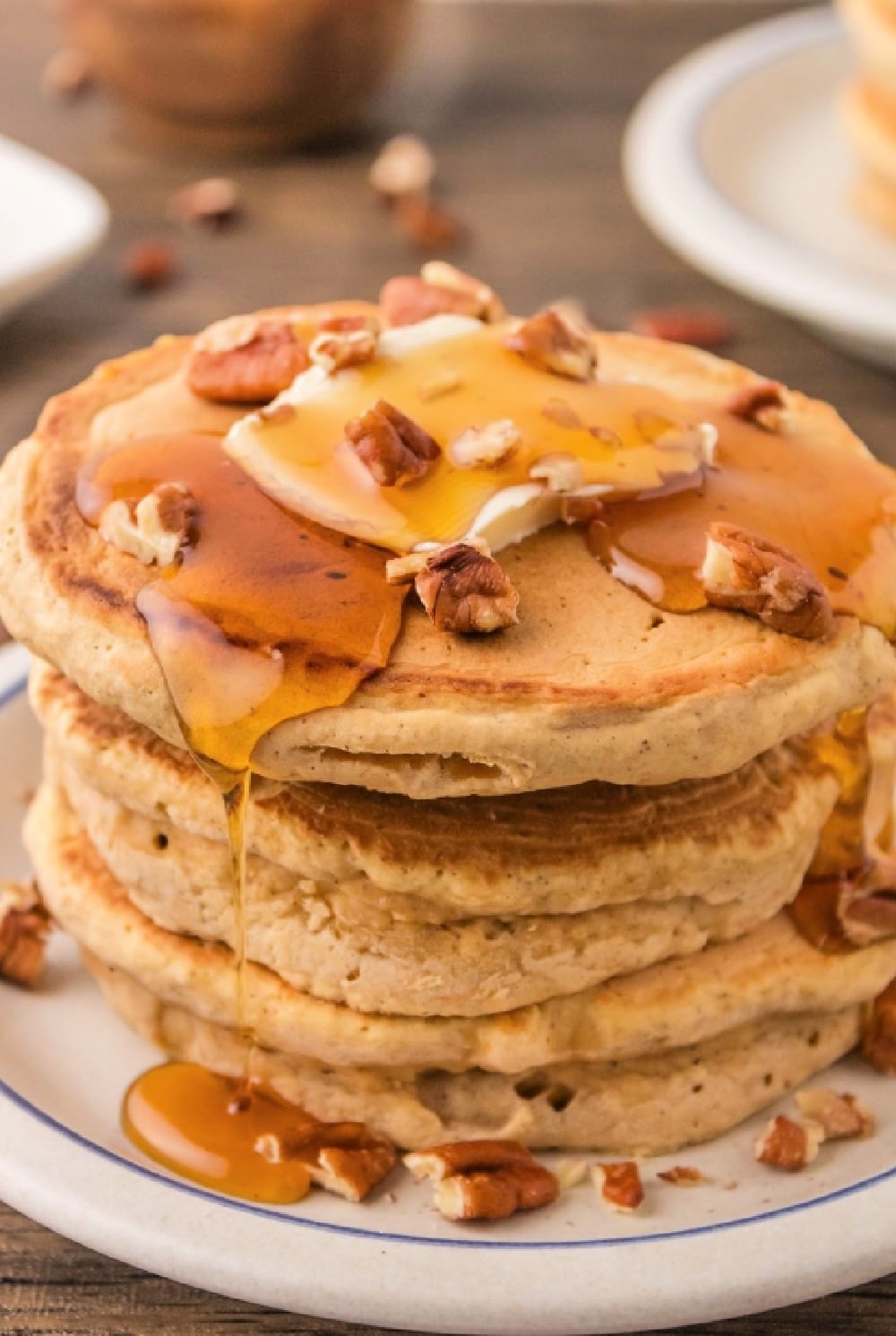 pumpkin pancake stack with syrup and nuts on the top