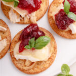 Leftover Thanksgiving turkey, brie and cranberry sauce on crackers
