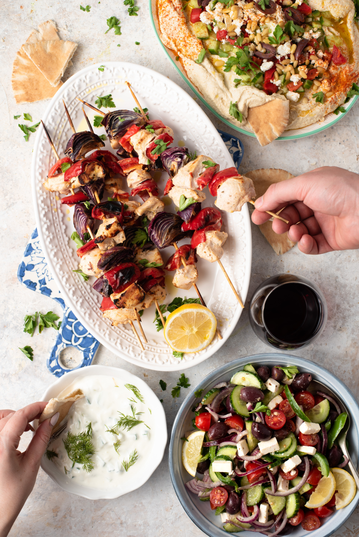 A gorgeous Greek meal with Tzatziki sauce, Greek kebobs, warm naan bread and layered hummus