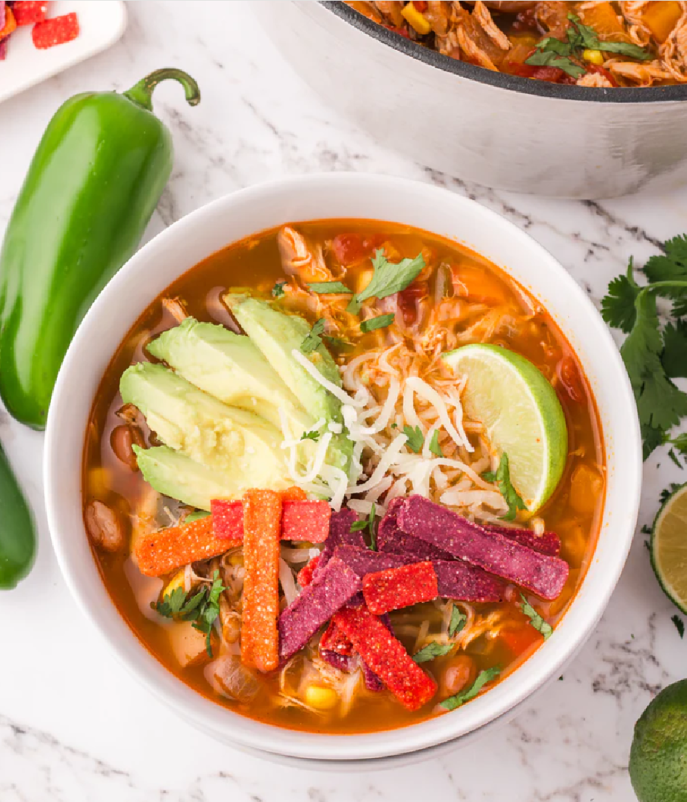 a bowl of southwest fiesta taco soup with chunks of chicken, corn and beans