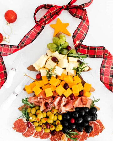 a holiday Christmas tree board with cheese, olives and nuts