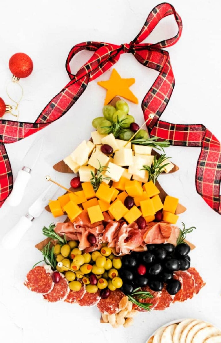 a holiday Christmas tree board with cheese, olives and nuts