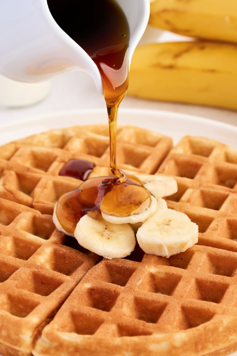 homemade banana waffles with syrup drizzled on top