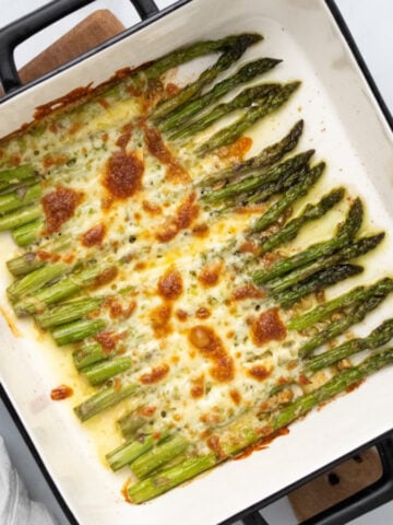 Asparagus topped with garlic and mozzarella in a baking dish