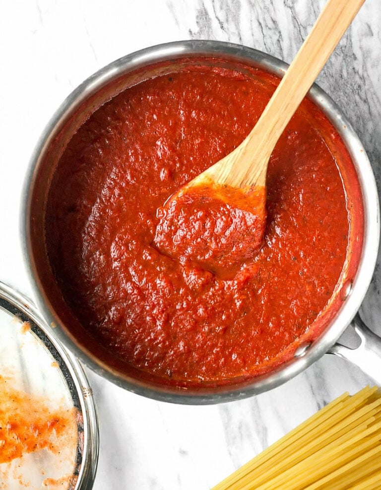 Homemade meatless spaghetti sauce in a saucepan with a wooden spoon.